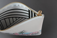 Load image into Gallery viewer, Close up of clutch bag with brass zipper and black and white interior
